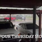 Two vehicles parked under a carport as heavy rain pours down at Paragon Communications, Elk City.